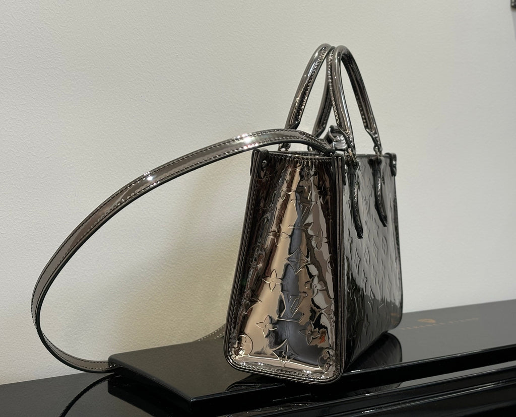 Louis Vuitton handbag with top handles and shoulder strap, glossy dark and metallic graphic pattern