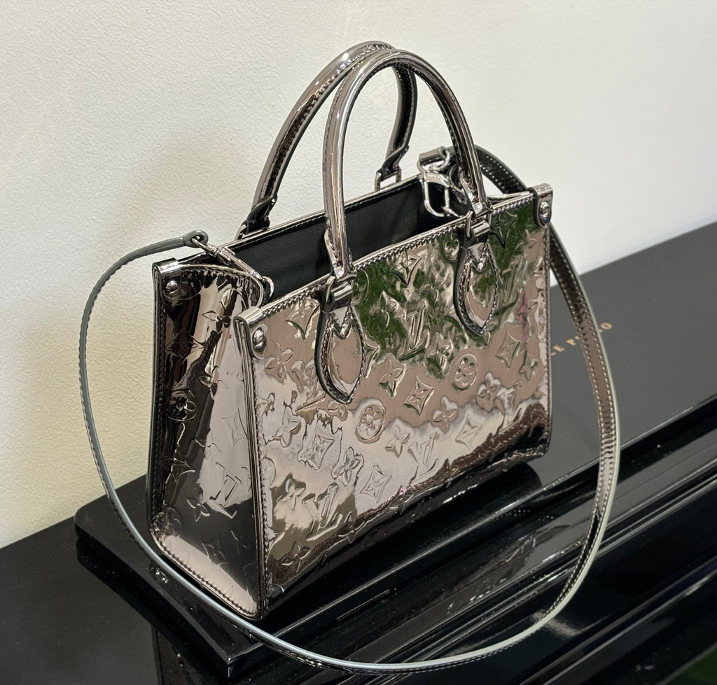Louis Vuitton handbag with top handles and shoulder strap, glossy black and metallic multicolor pattern