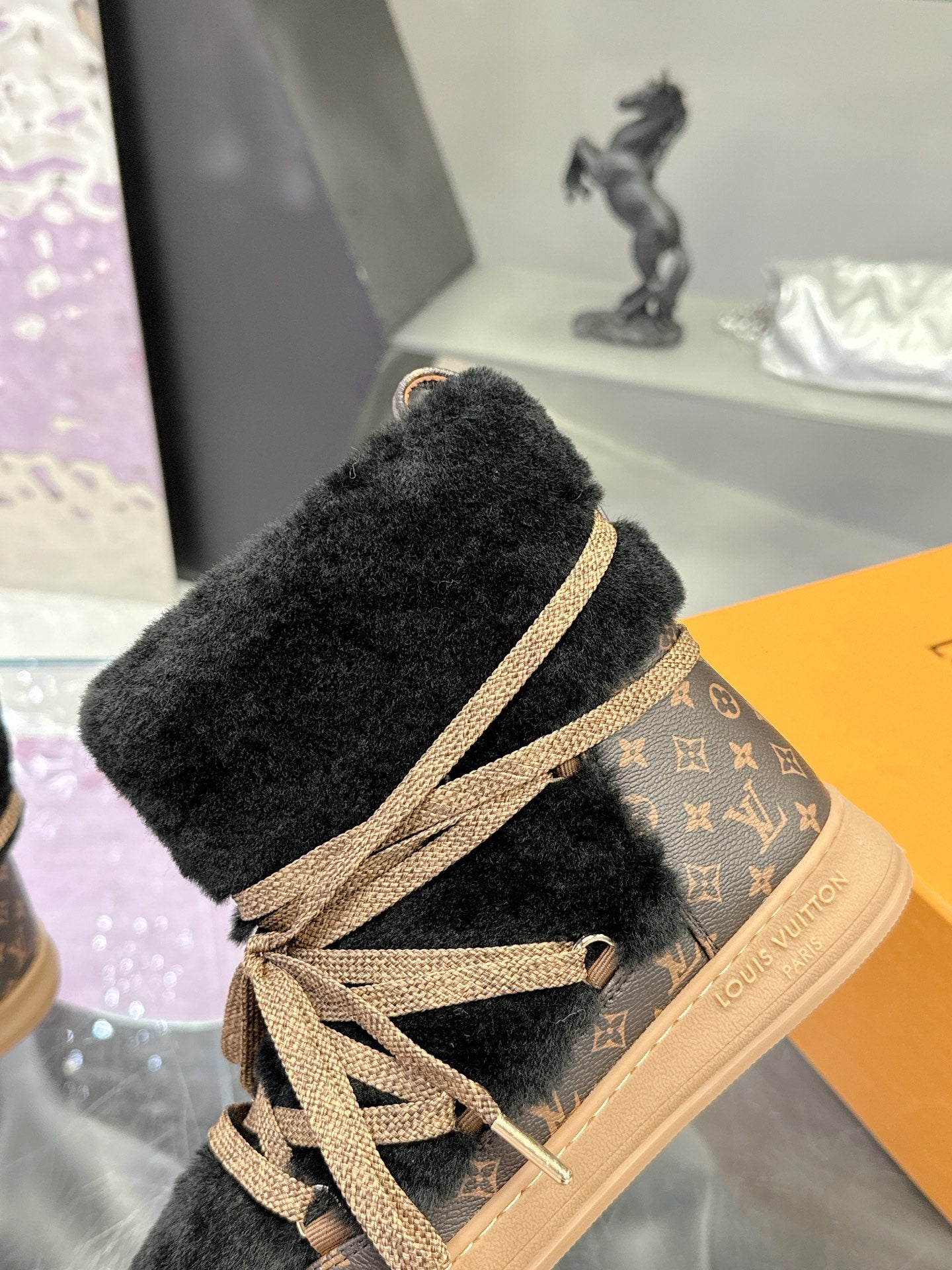 Black faux-fur lace-up ankle boot with tan laces and Louis Vuitton monogram