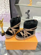 Pair of black faux-fur lace-up ankle boots with tan laces and monogram panel