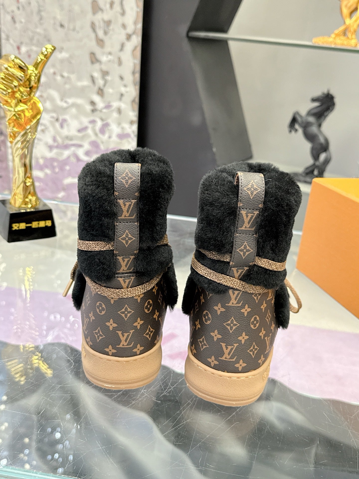 Back view of black faux-fur Louis Vuitton ankle boots with tan monogram cuffs