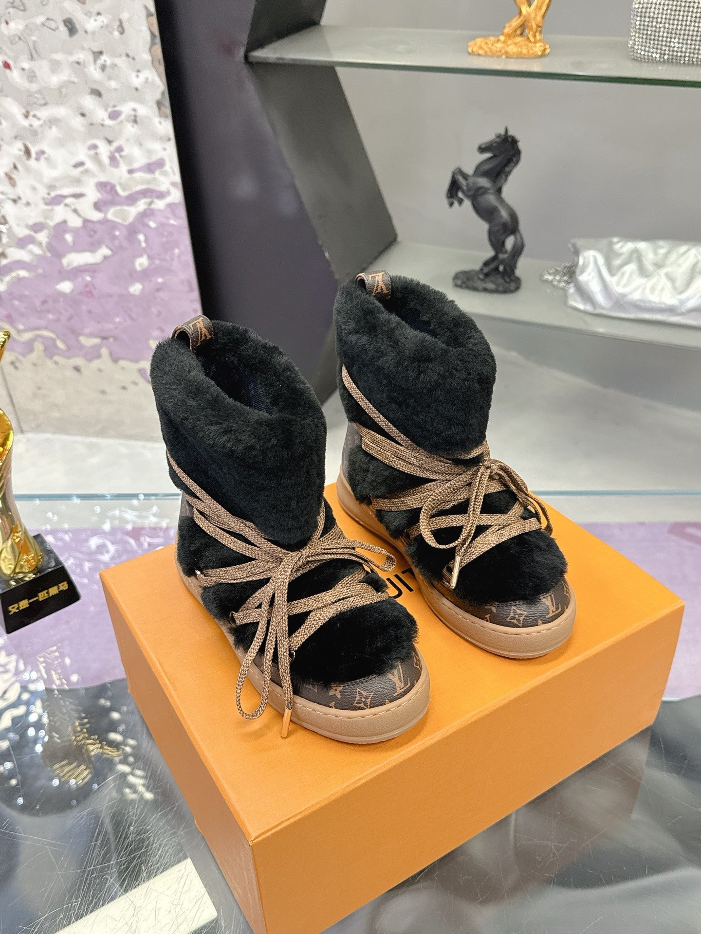 Black faux-fur lace-up ankle boots with tan laces and low light sole