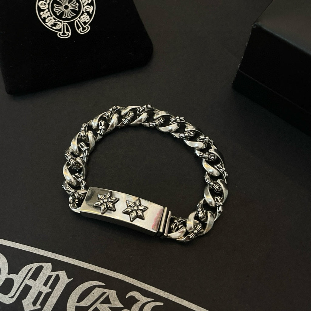 Silver-toned chain bracelet with rectangular clasp plate and two cross-flower emblems