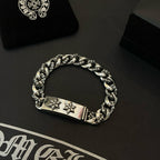 Silver-toned chain bracelet with rectangular clasp plate and two cross-flower emblems