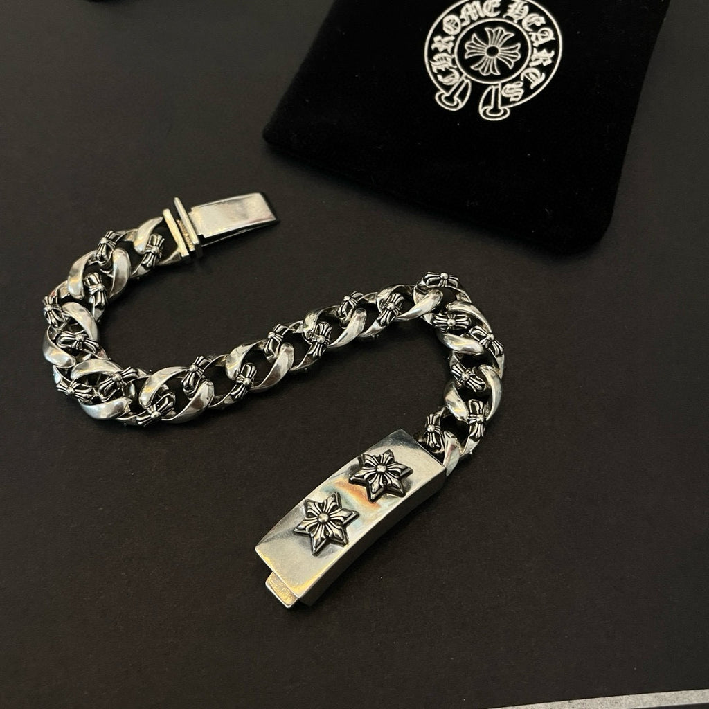 Silver-toned chain bracelet with rectangular center clasp plate and two cross-flower emblems