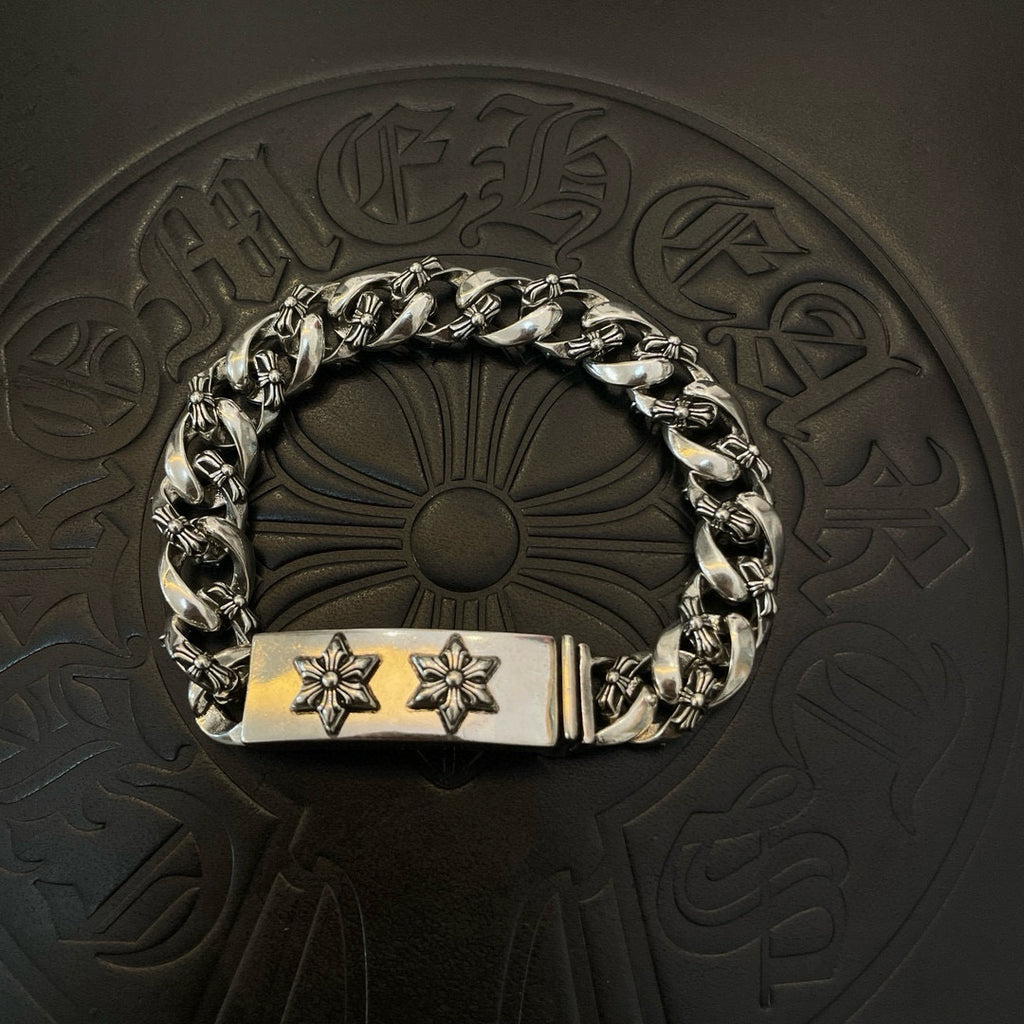 Silver-toned chain bracelet with rectangular clasp and two cross-flower emblems