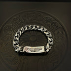 Silver-toned chain bracelet with rectangular tag clasp and two cross-flower emblems