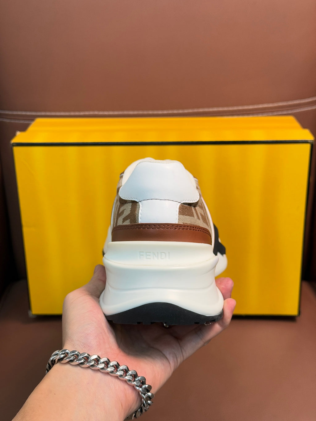 Fendi unisex sneakers with heel view, brown and tan uppers, white sole, and logo strap