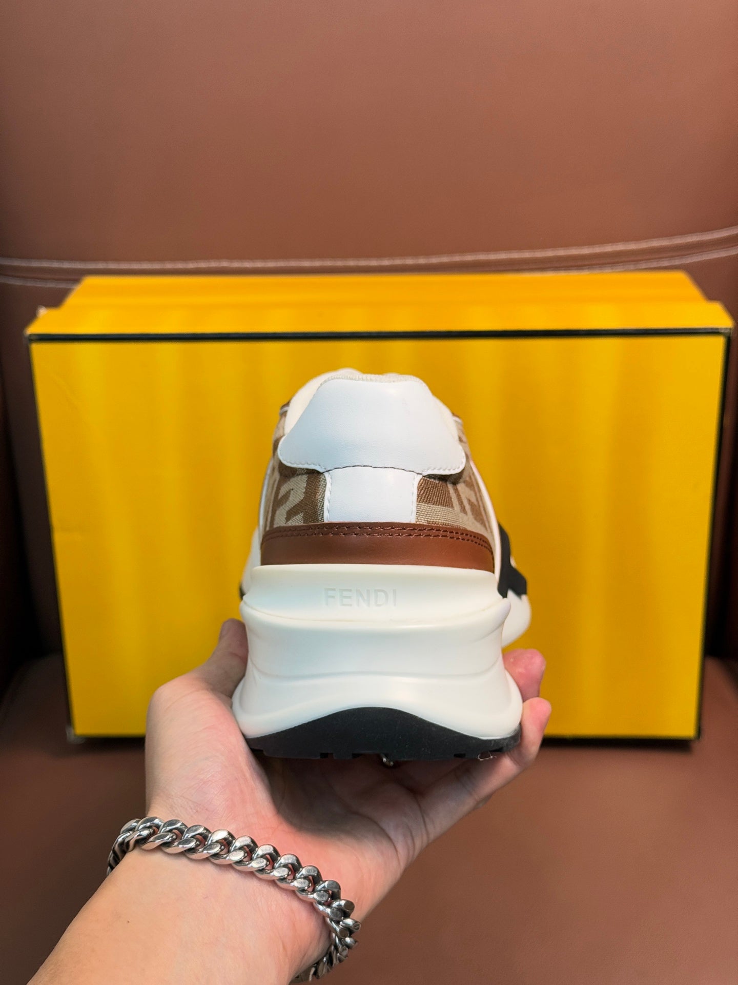 Fendi unisex sneakers with heel view, brown and tan uppers, white sole, and logo strap