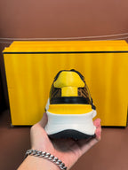Fendi unisex sneakers heel view, white midsole and outsole with yellow upper details.