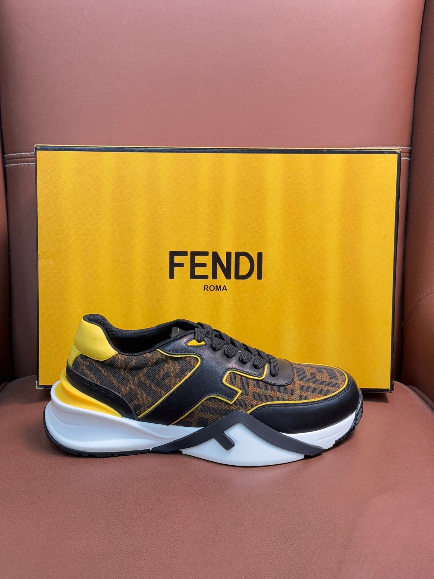 Fendi unisex sneakers, dark FF pattern with yellow trim and white sole, lace-up design.