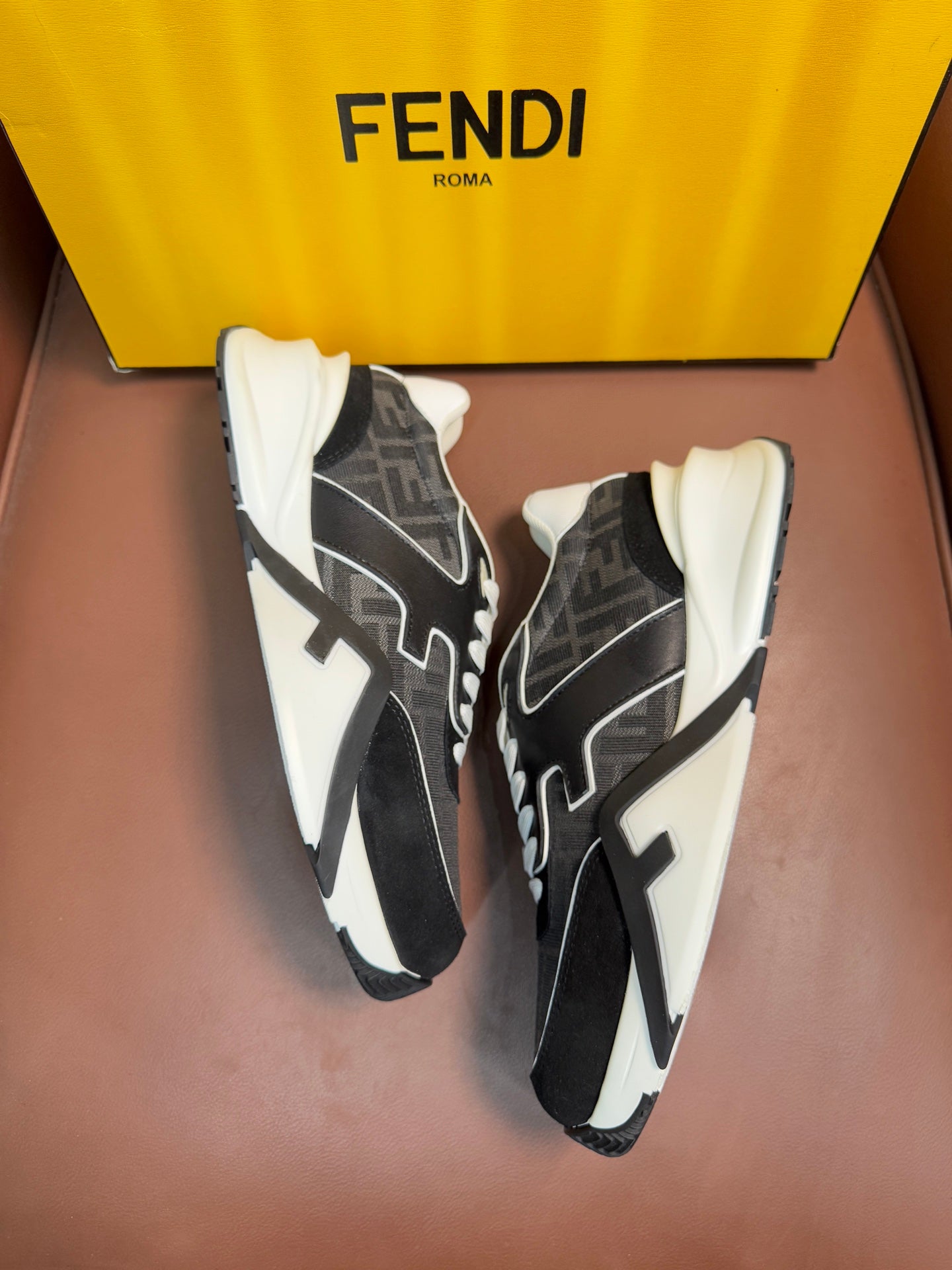 Black and gray Fendi unisex sneakers with white laces and bold side logo details.
