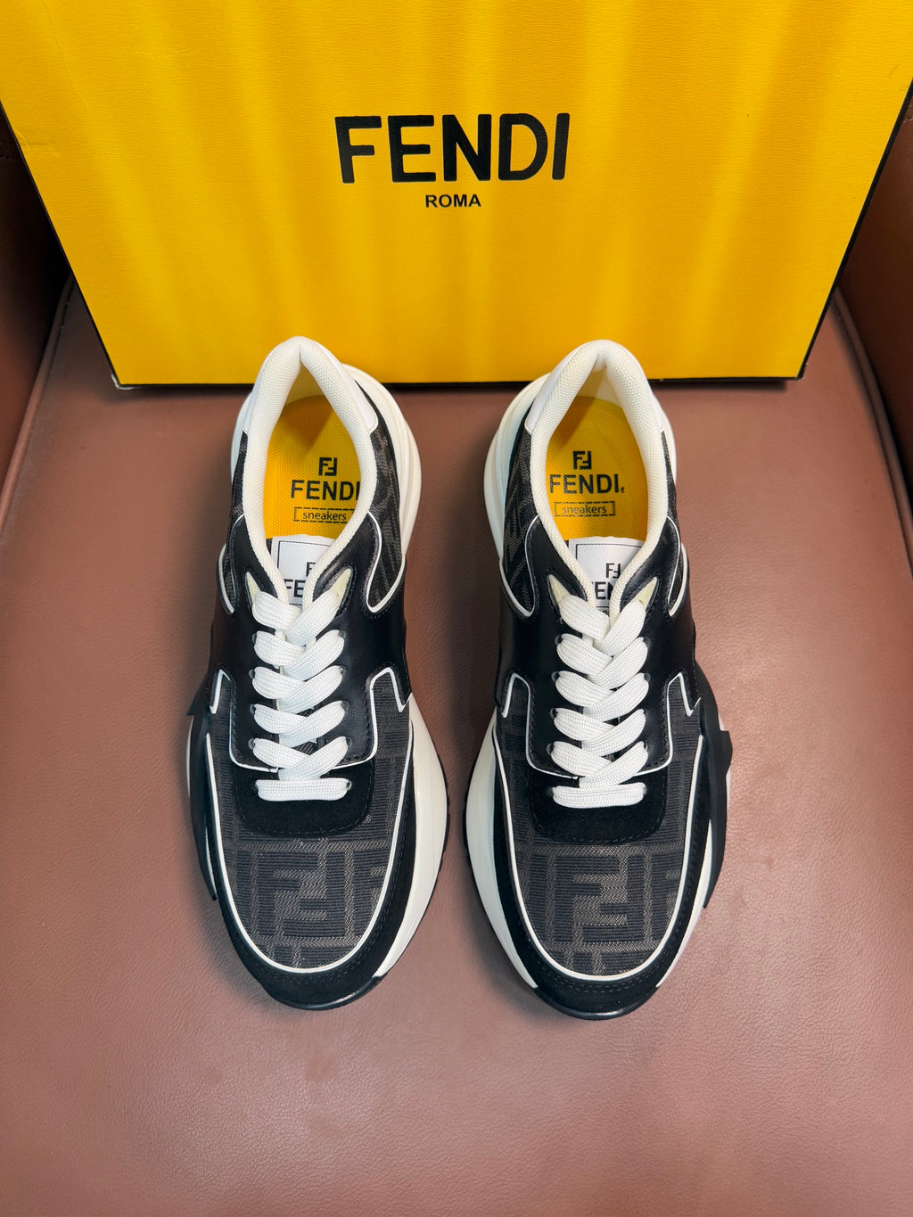 Black and gray Fendi unisex sneakers with white laces and contrast side panels.