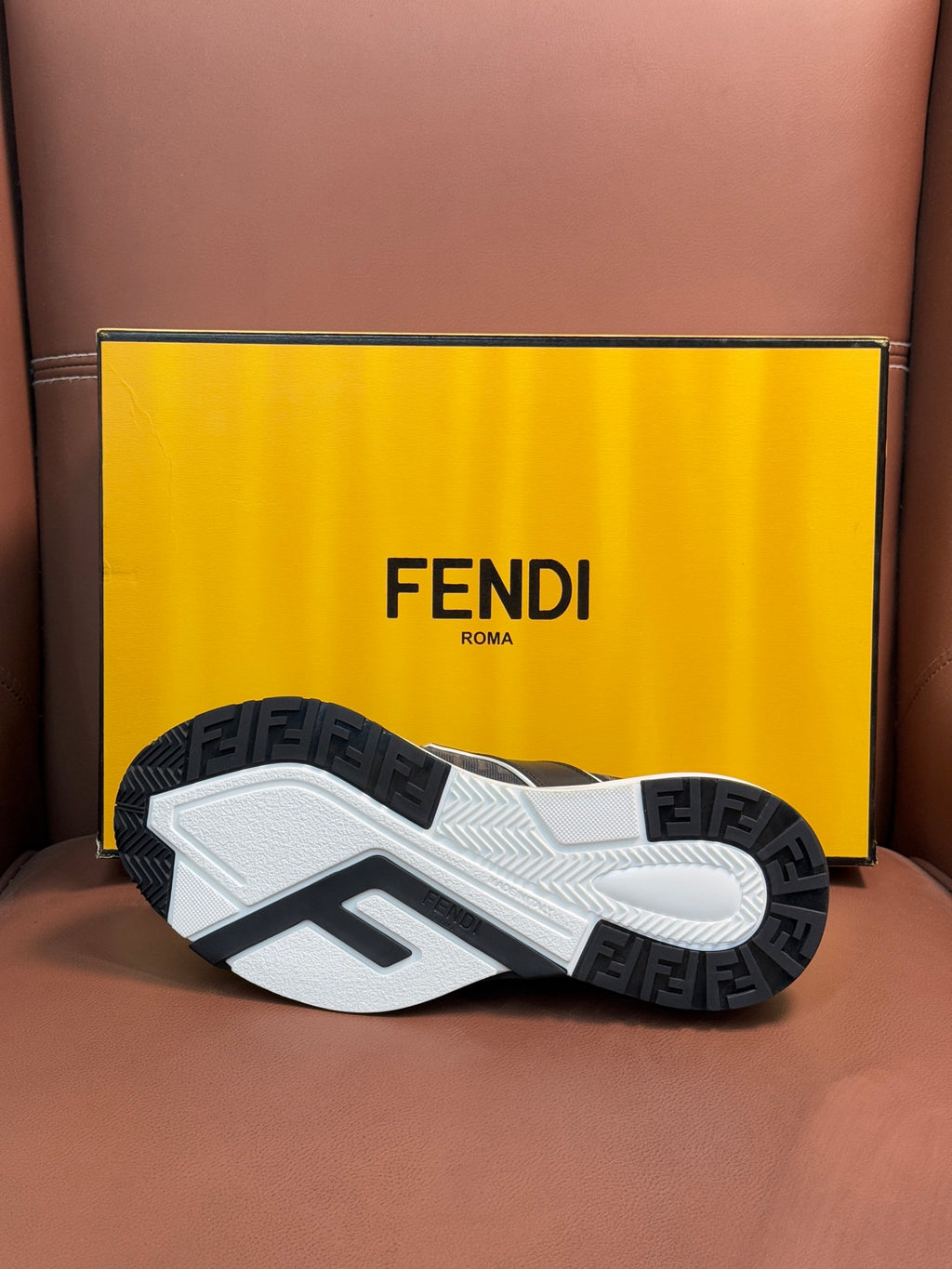Fendi unisex sneakers outsole view, textured tread on white and dark rubber base.