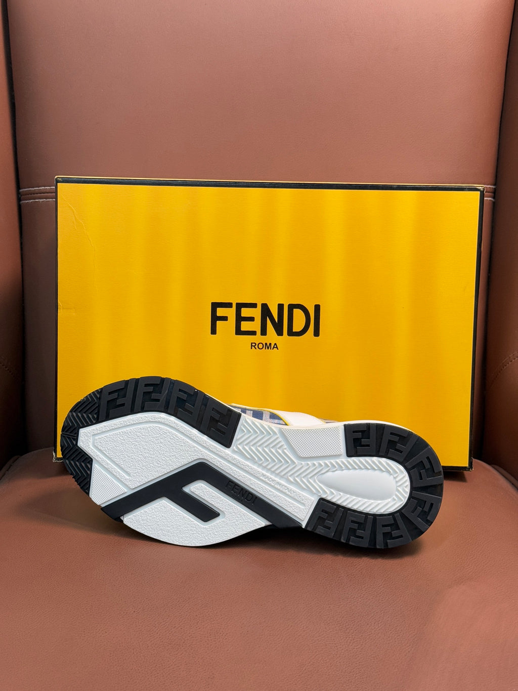 FENDI sneaker outsole with textured tread and dark rubber pods under the white shoe.