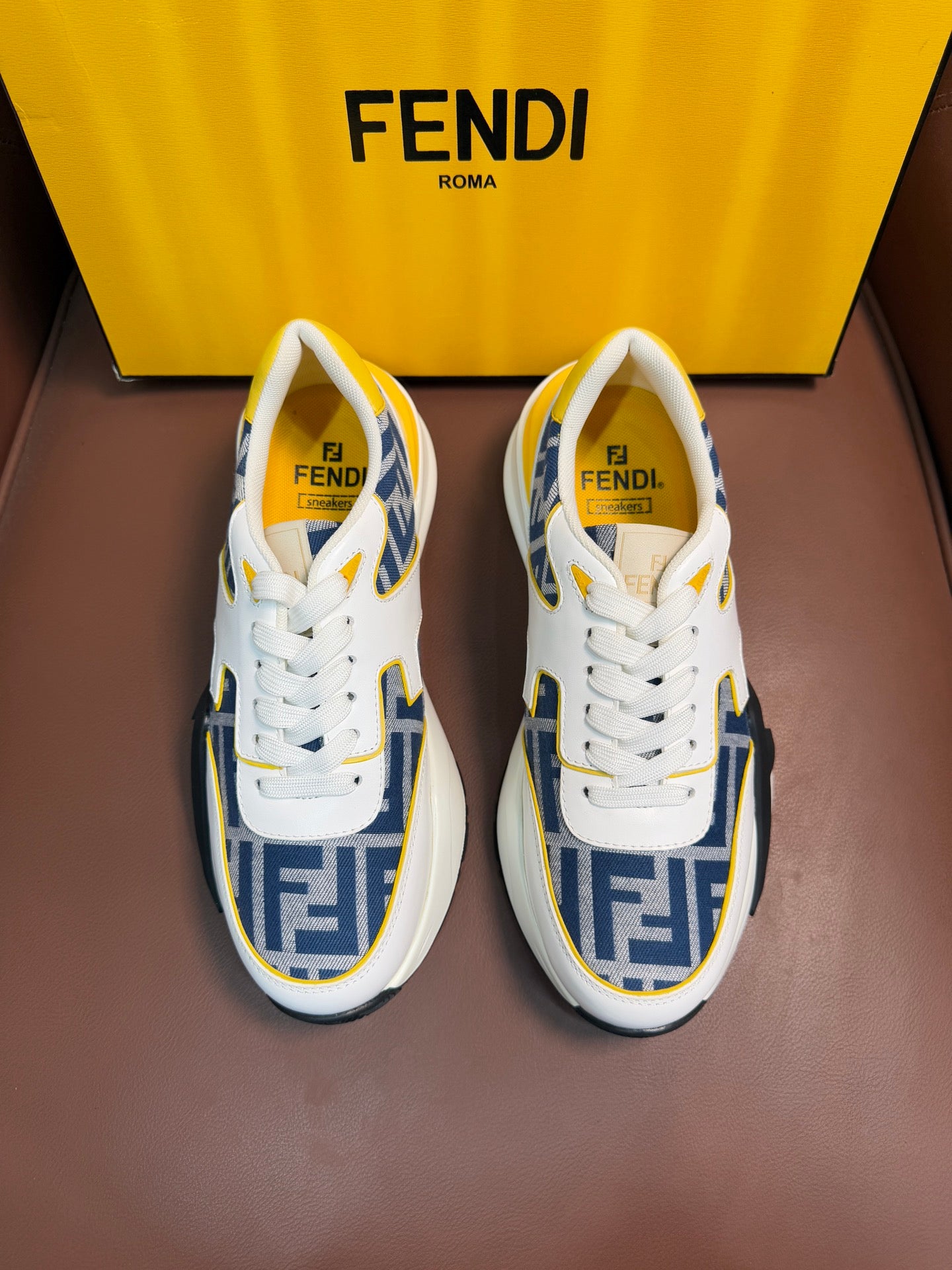 White and blue FF logo low-top sneakers with yellow accents, lace-up, chunky sole.