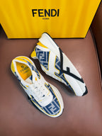 White FENDI sneakers with blue FF panels, yellow trim, lace-up, thick rubber sole.