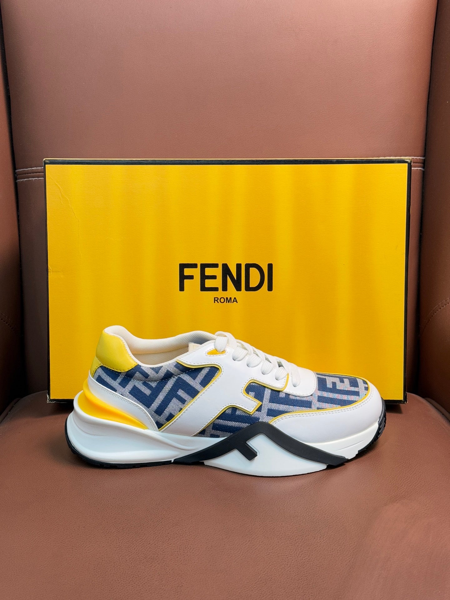 White FENDI sneakers with blue FF logo uppers and yellow accents, lace-up, chunky sole.