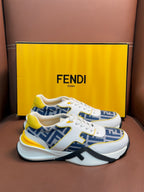 White FENDI low-top sneakers with blue FF panels, yellow accents, lace-up, thick sole.