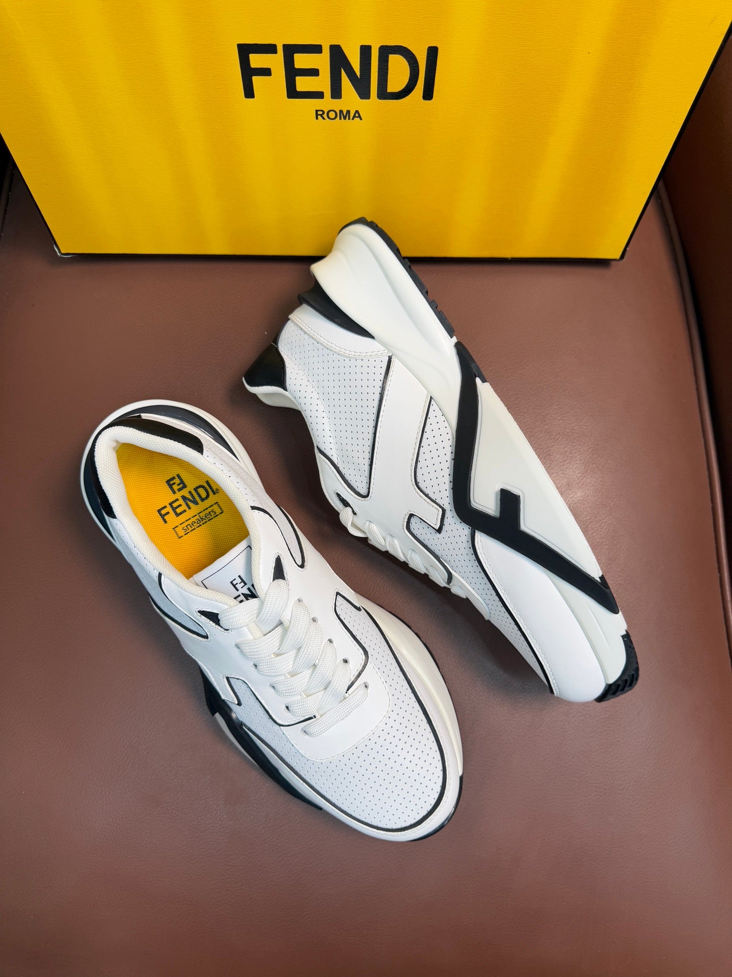 Pair of white lace-up sneakers with black side logo appliqués