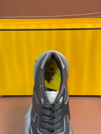 Fendi unisex sneaker tongue close-up, dark gray lace-up with Fendi branding inside.