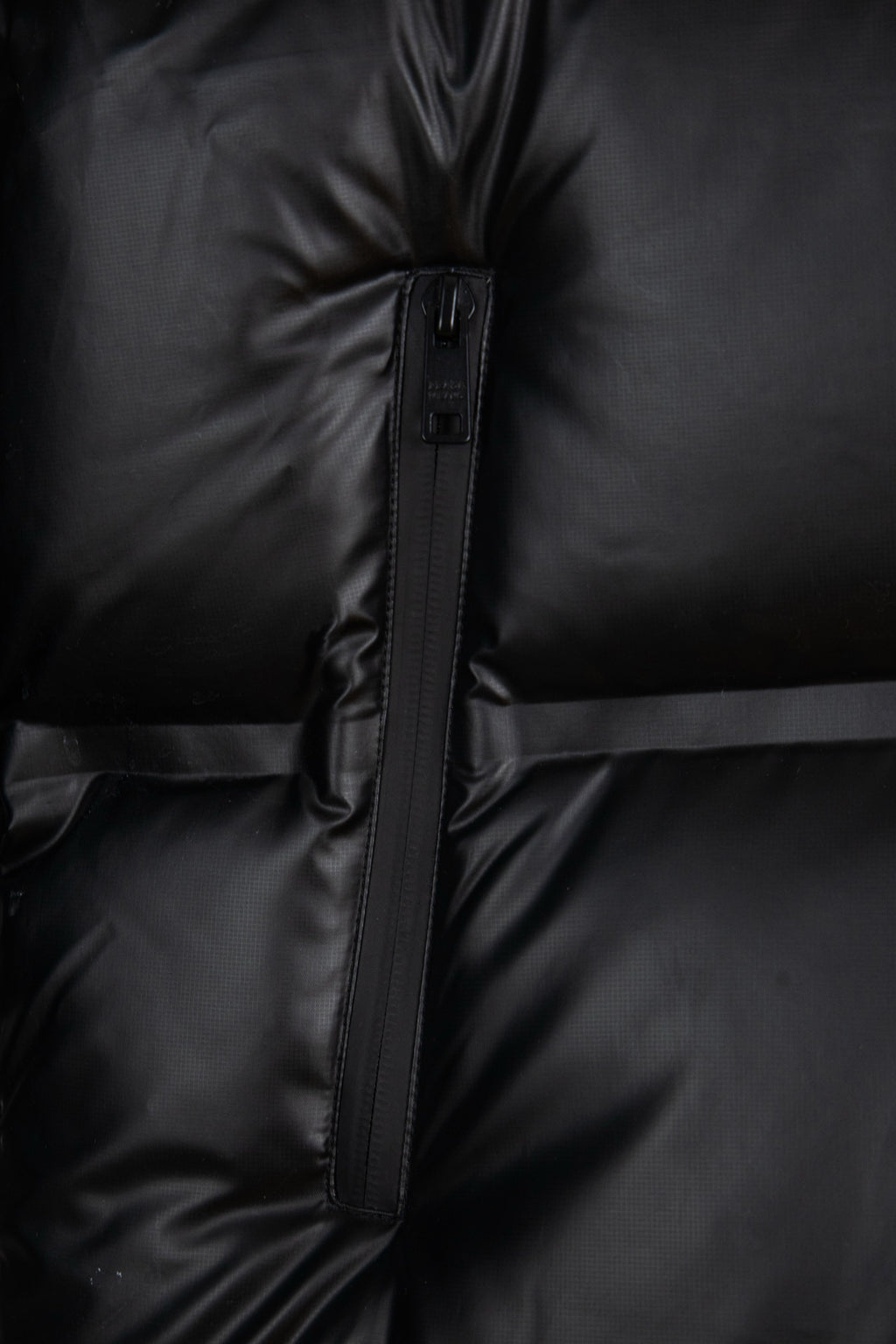Prada long puffer jacket close-up of front zipper and quilted paneling