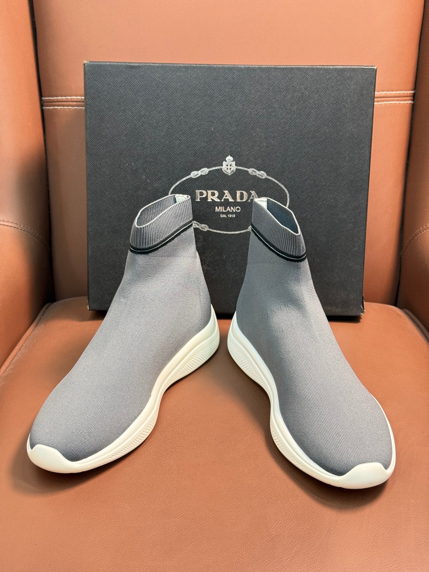 Prada unisex knit sock sneakers pair in light gray with white soles and curved toe