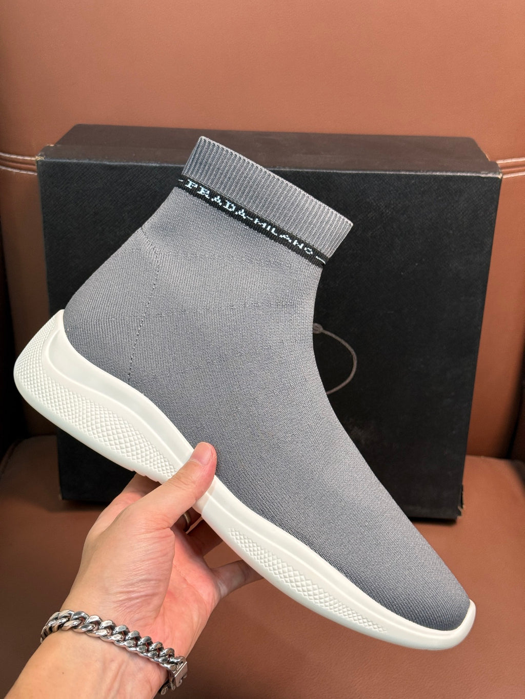 Prada unisex sock sneakers close-up, light gray knit with branded cuff strip