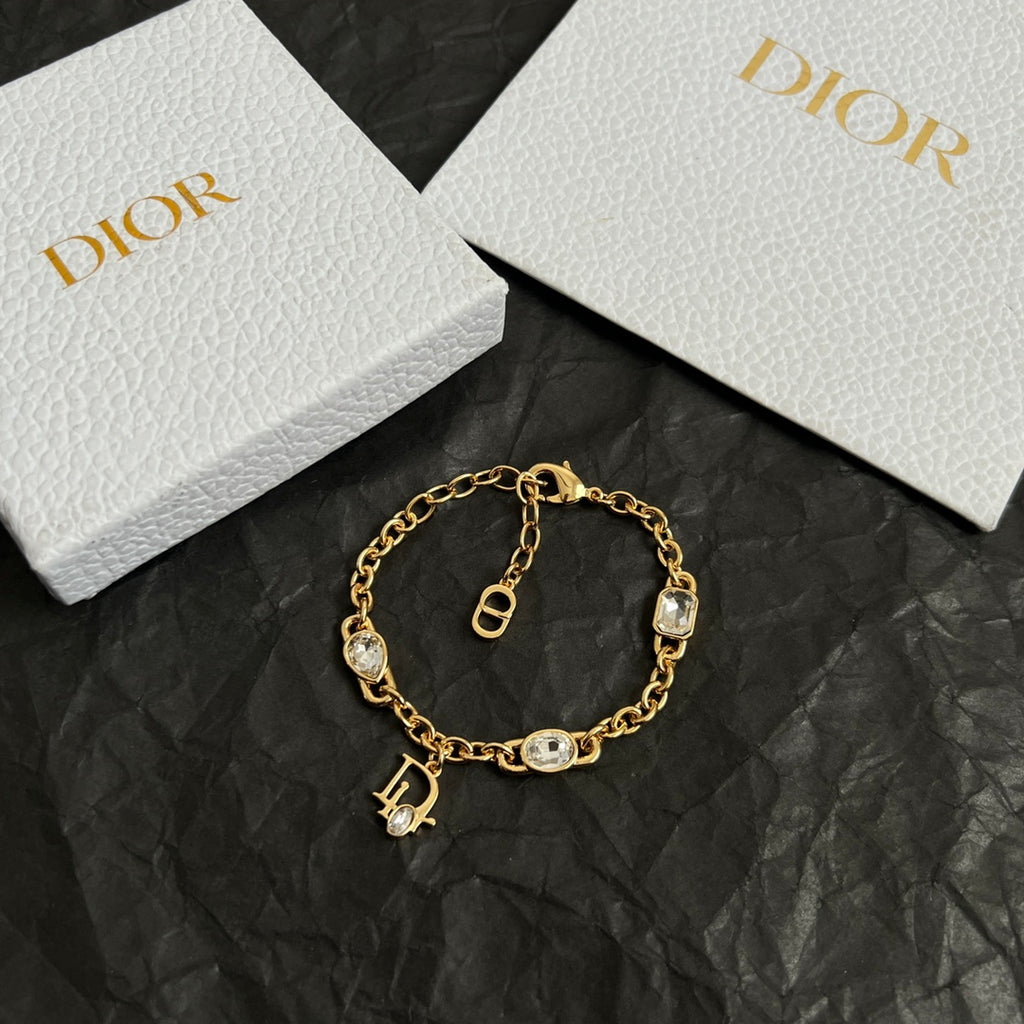 Gold charm bracelet with oval stones, toggle clasp, and D pendant