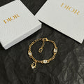 Gold charm bracelet with oval stones, toggle clasp, and D pendant