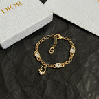 Gold charm bracelet with oval stones, small padlock charm, and D pendant