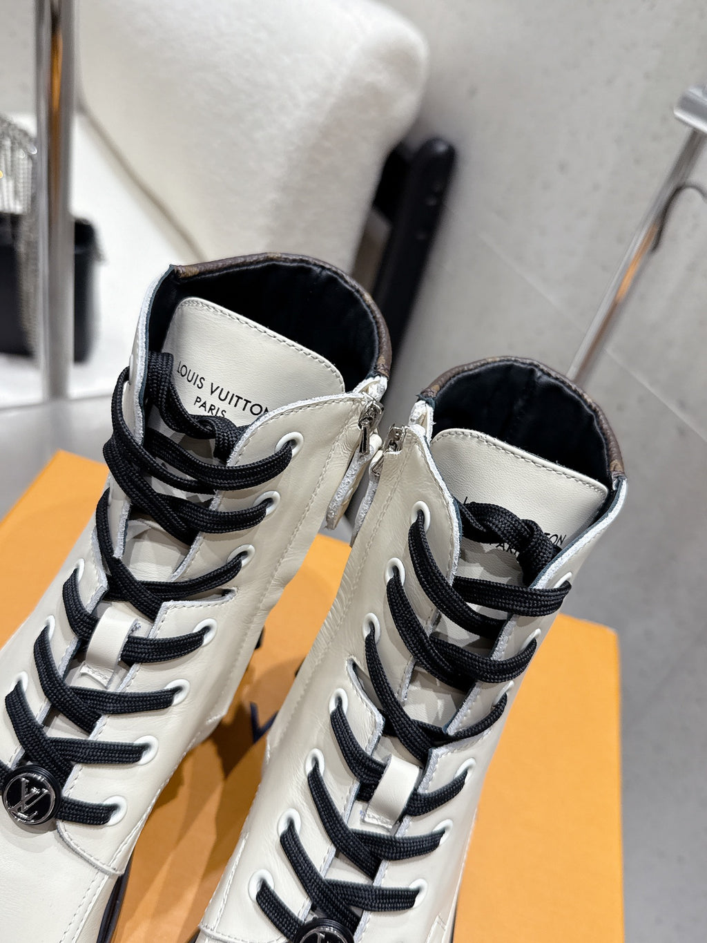 Louis Vuitton high-top shoes, close-up of tongues and black lace eyelets