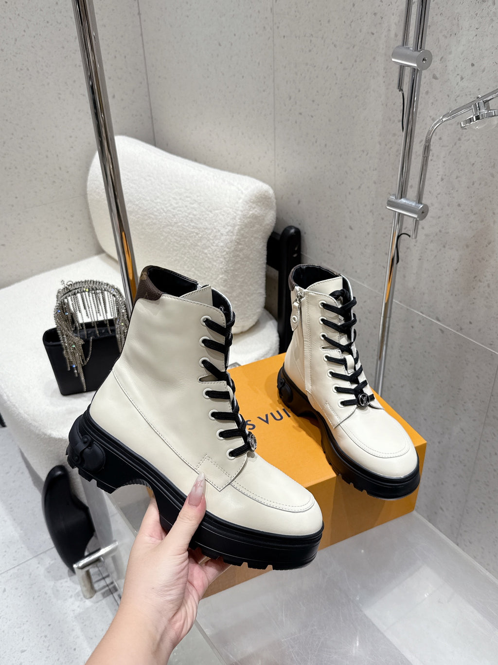 Louis Vuitton white leather high-top shoes, hand holding front on box