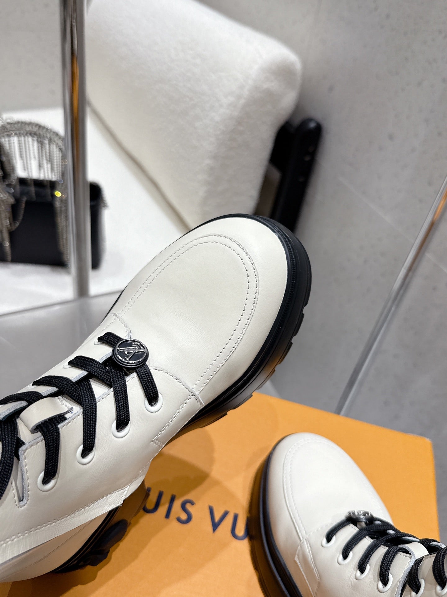Louis Vuitton white high-top shoe side, black laces and stitched toe detail