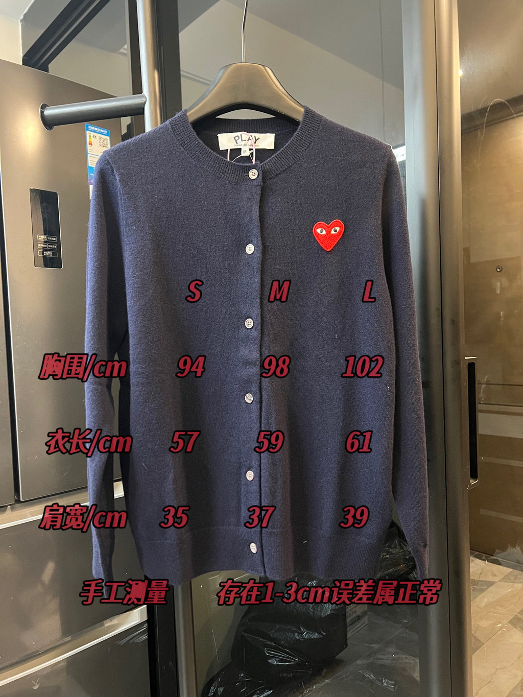 Dark navy knit cardigan with button front and small red heart patch on the left chest