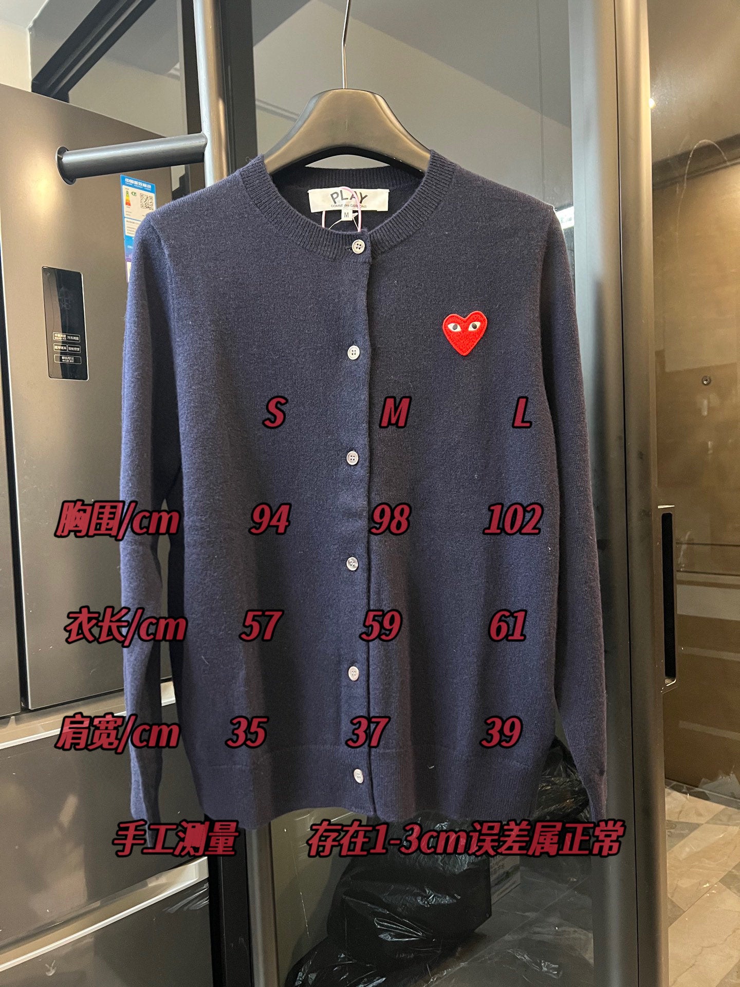 Dark navy knit cardigan with button front and small red heart patch on the left chest