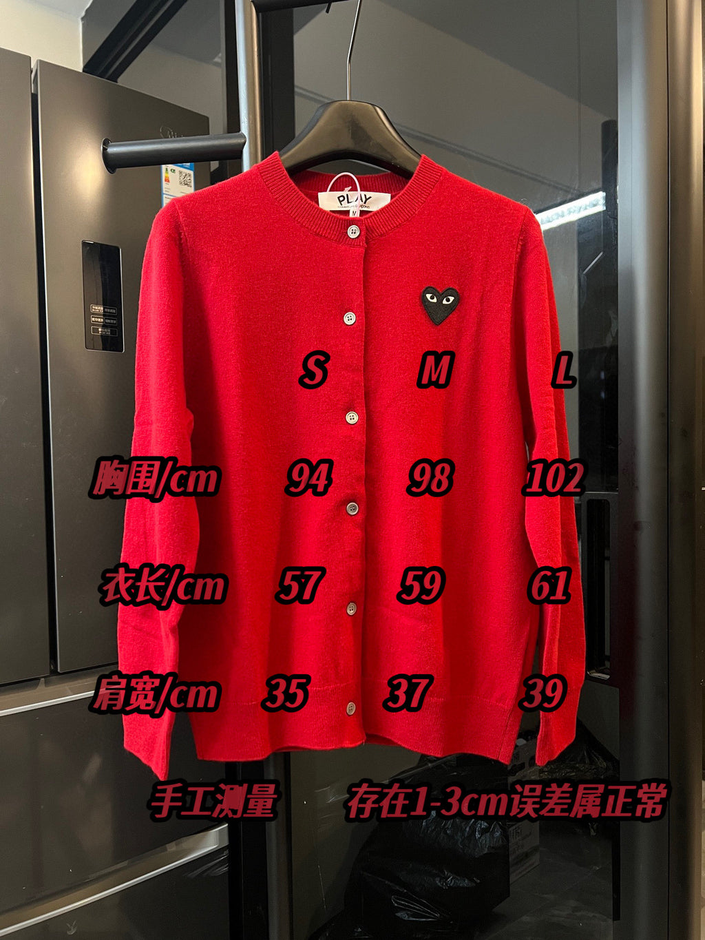 Red knit cardigan sweater front with button placket and black cat-face applique