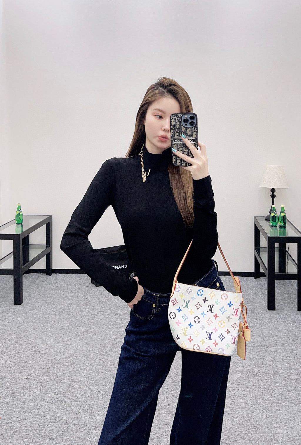Louis Vuitton black long-sleeve mock-neck top, paired with jeans and crossbody bag