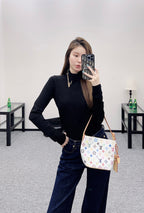 Louis Vuitton black long-sleeve mock-neck top, paired with jeans and crossbody bag