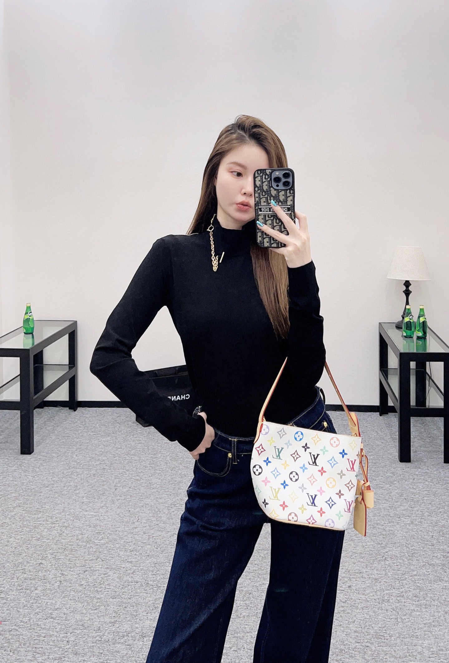 Louis Vuitton black long-sleeve mock-neck top, paired with jeans and crossbody bag