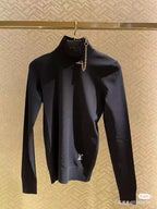 Louis Vuitton black long-sleeve mock-neck top with gold chain charm detail