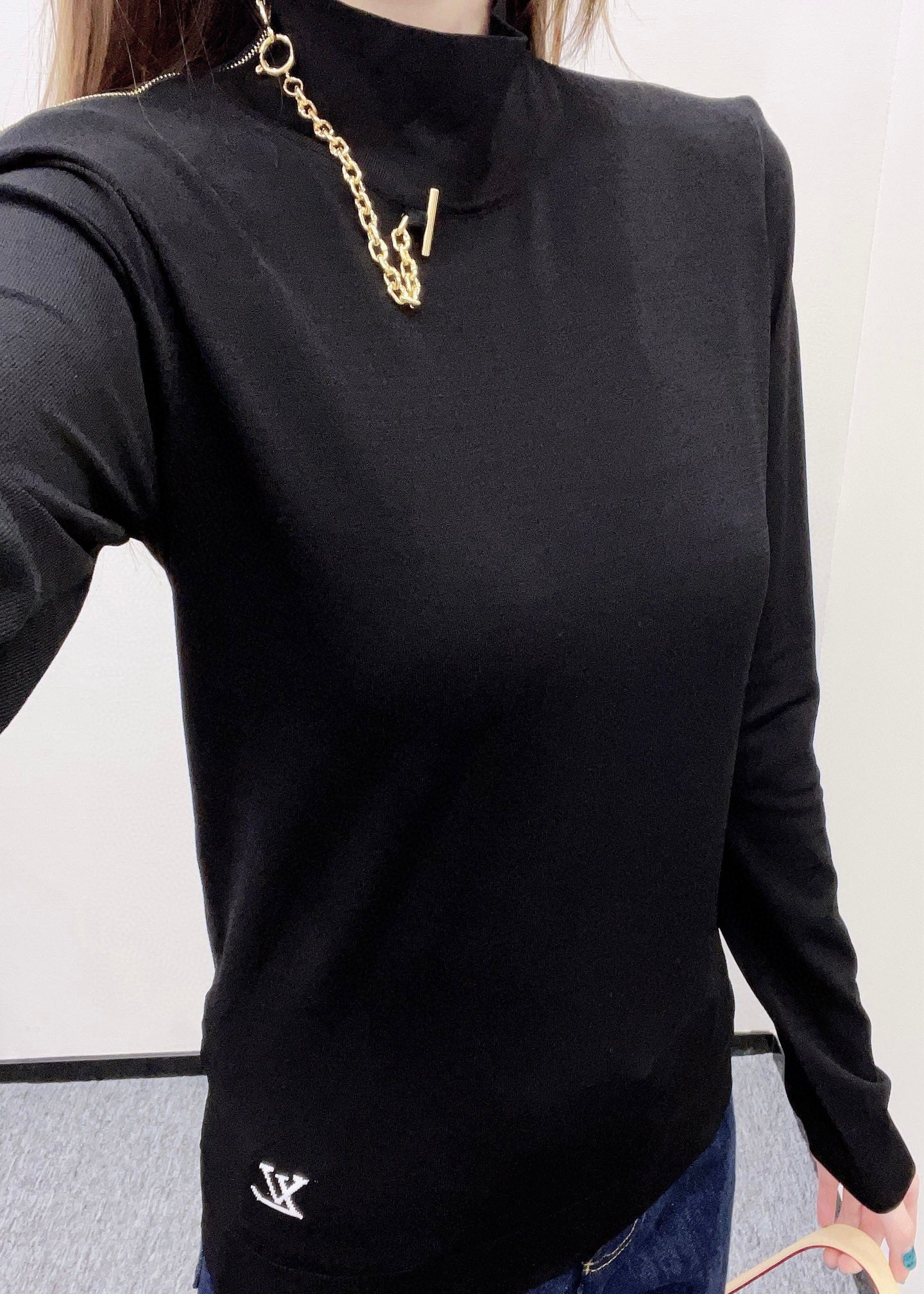 Louis Vuitton black long-sleeve mock-neck top with layered gold chain at collar