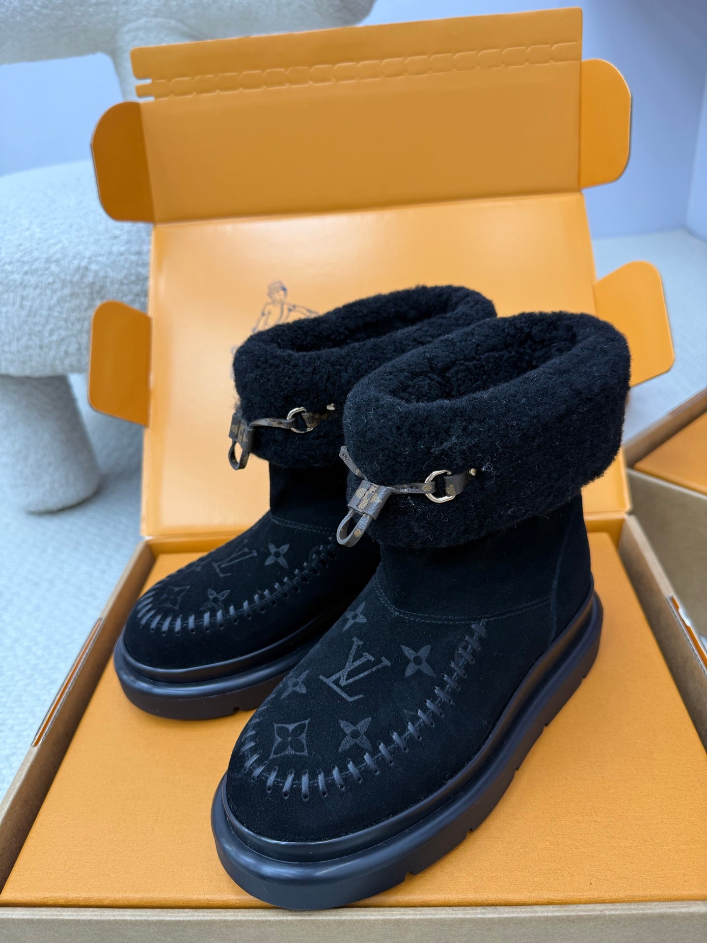 Dark navy ankle boots with shearling lining, buckle detail, and Louis Vuitton monogram print