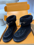 Side view of dark navy Louis Vuitton high-top boots with shearling cuff and buckle strap