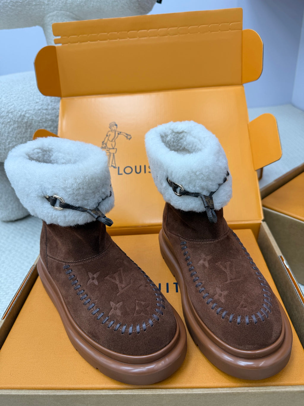 Louis Vuitton ladies shoes, pair in brown suede with light blue shearling cuffs and stitched side details.