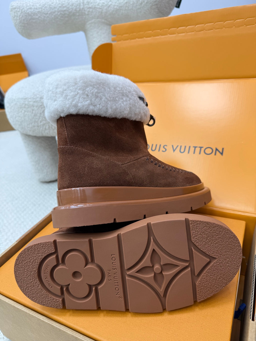 Louis Vuitton ladies shoes outsole view with light blue shearling cuff on brown suede boot.
