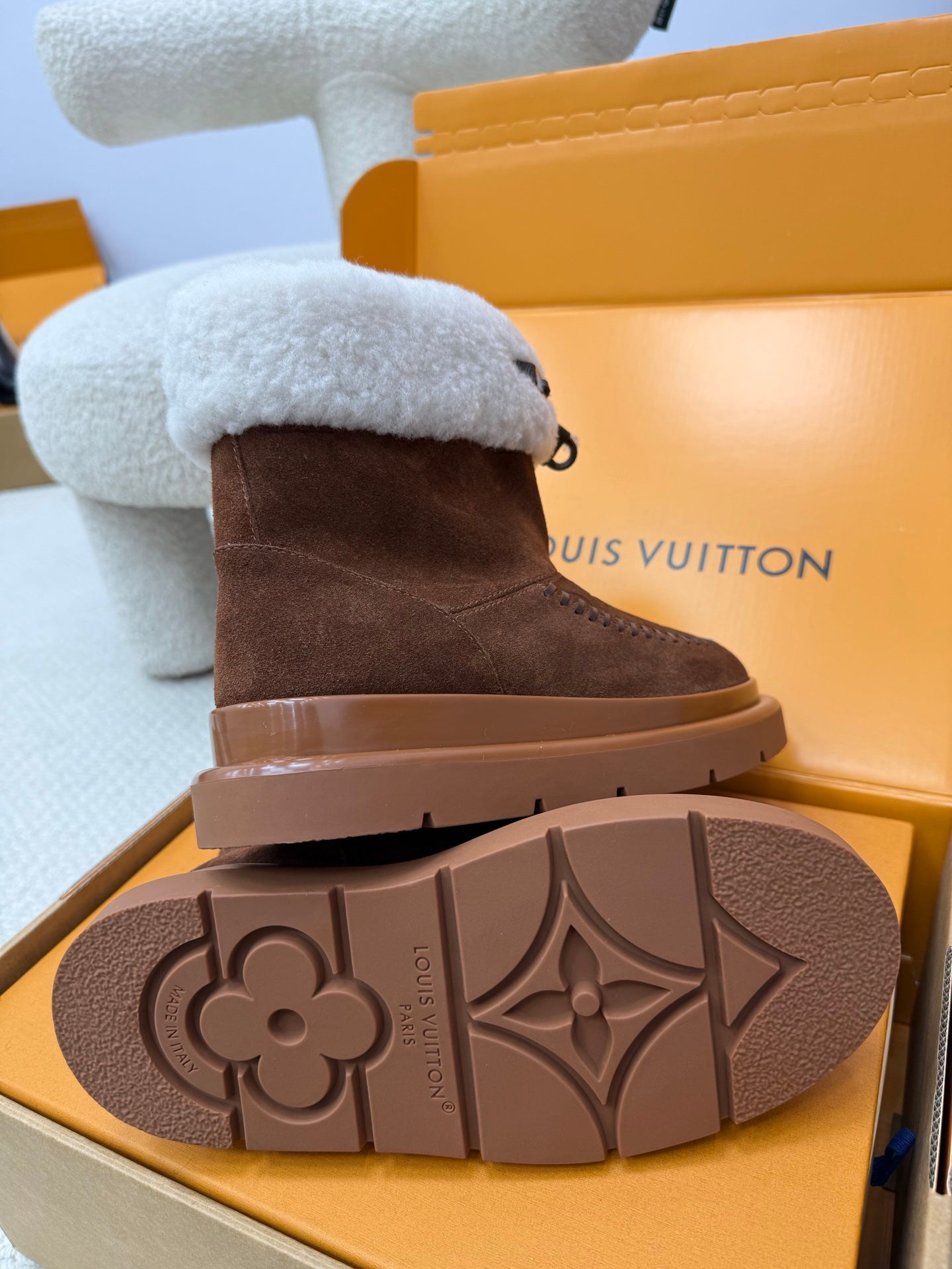 Louis Vuitton ladies shoes outsole view with light blue shearling cuff on brown suede boot.