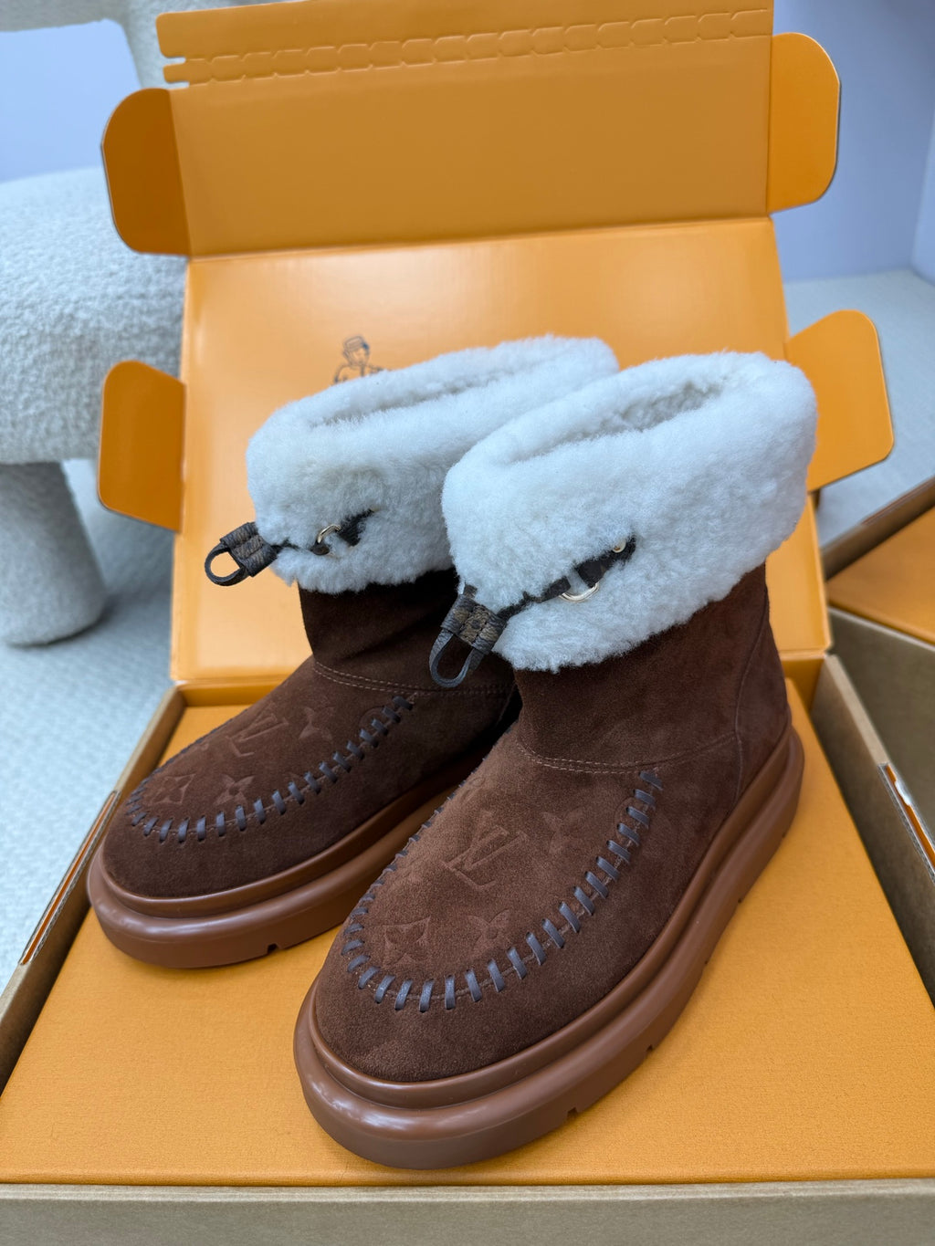 Louis Vuitton ladies shoes with brown suede upper and light blue shearling straps with tie details.