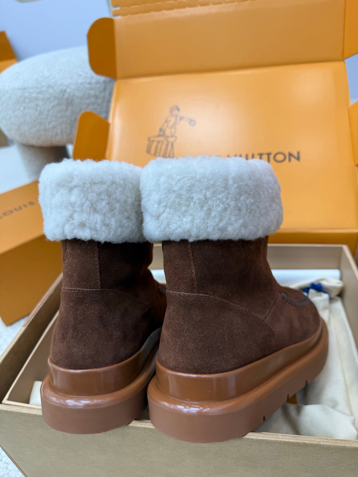 Louis Vuitton ladies shoes, brown suede boots with light blue shearling cuffs and chunky brown sole.