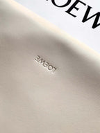 Leather fabric closeup with subtle embossed lettering on a cream surface